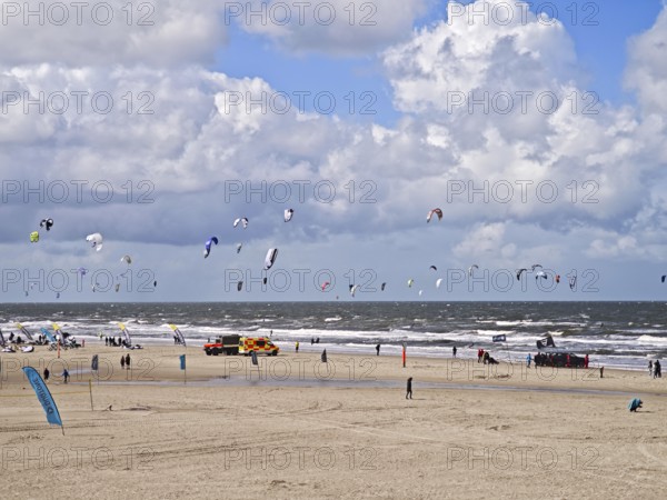 California kitesurfing Masters 2025 on the edge of the Wadden Sea UNESCO World Heritage Site, North Sea, kitesurfing sport, flying kites, fun, competition, strong wind, whitecaps, beach, summer, sunshine, blue sky, white clouds, ambulance, Ording, Sankt Peter-Ording, Schleswig-Holstein, Germany