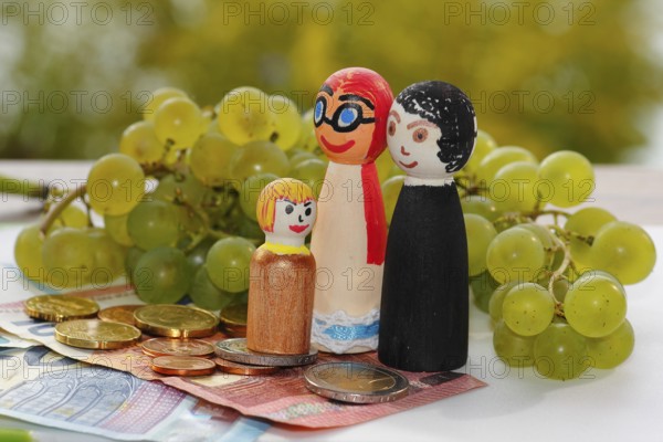 Wooden cone family with grapes and coins and banknotes, North Rhine-Westphalia, Germany