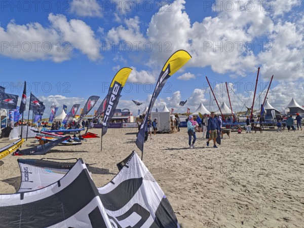 California kitesurfing Masters 2025, Kite Village tents with kite equipment for sale, marketplace, try out, kitesurfing on the North Sea beach, blue sky, sun, summer, trampoline, Ording, Sankt Peter-Ording, Schleswig-Holstein, Germany