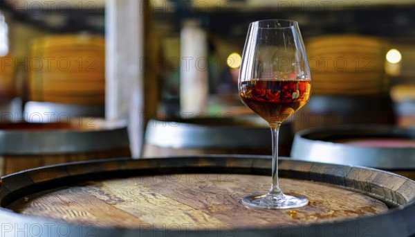 Glass of 10-year-old tawny wine placed on a barrel in a vineyard restaurant, AI generated