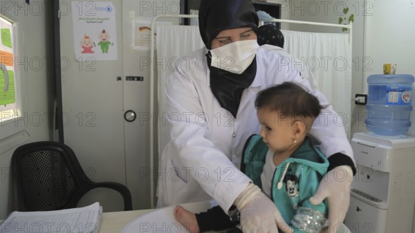 A doctor examining a refugee child for malnutrition in the camp using weight and height measurement. Aleppo, Syria October 18, 2022, Aleppo, Syria