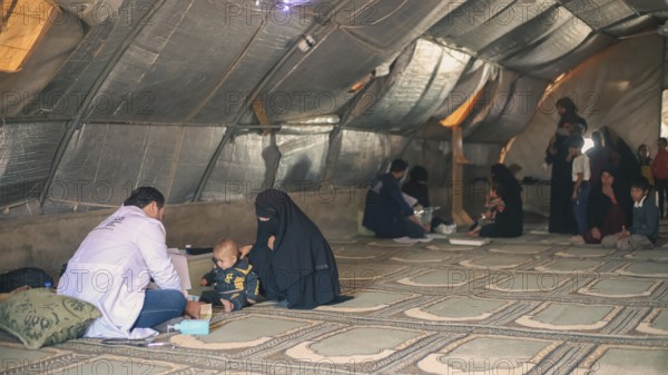 A doctor examining a woman inside a mobile medical point dedicated to treating Syrian refugees. Aleppo, Syria May 28, 2022, Aleppo, Syria