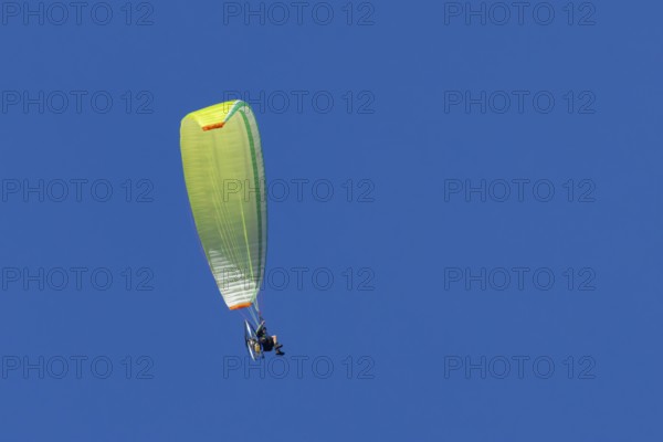 Paraglider flying in a blue sky, England, United Kingdom