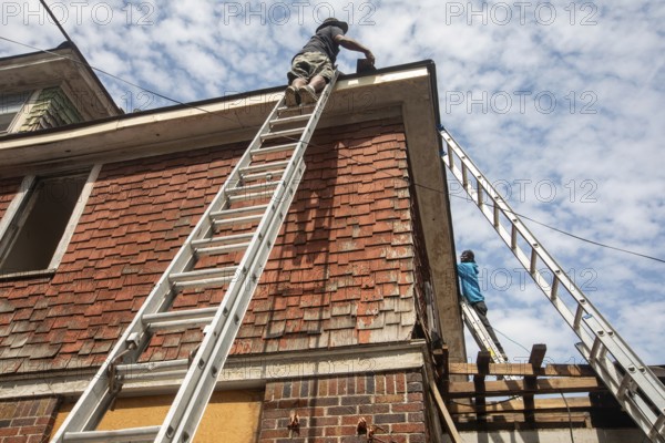 Detroit, Michigan - Workers re-roof a house they are remodeling in the Morningside neighborhood that had been vacant for many years. Detroit lost nearly two-thirds of its residents from 1950 to 2020 but has been growing modestly in recent years