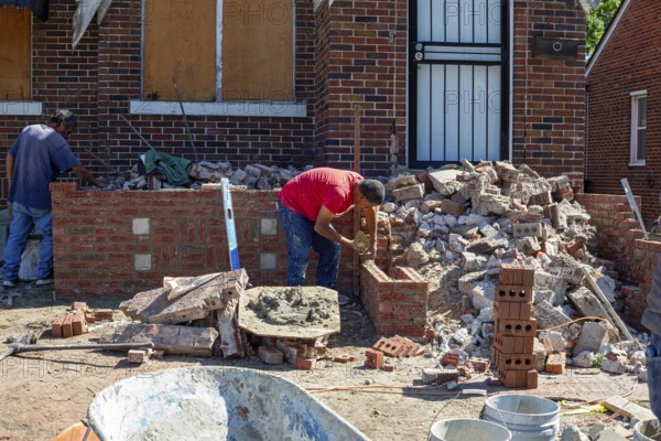 Detroit, Michigan - Workers rebuild the front porch of a house they are remodeling in the Morningside neighborhood. The house had been vacant for many years. Detroit lost nearly two-thirds of its residents from 1950 to 2020 but has been growing modestly in recent years