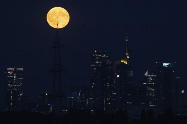 The full moon passes over the Frankfurt banking skyline, Frankfurt am Main, Hesse, Germany
