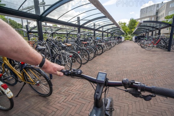 Bicycle parking spaces and boxes on the cycle path in the east of Utrecht, at Utrecht-Lunetten railway station, direct connection of the cycle path to the railway station and bus station, covered bicycle stands, on the Maarschalkerweerdpads cycle path, Netherlands