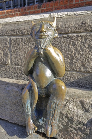 Sculpture Devil by Rolf Goerler 1999 sitting on the Devil's Stone, bronze sculpture, modern art, St. Mary's Church, Old Town, Lübeck, Schleswig-Holstein, Germany