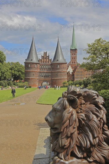 Lion figure at the historic Holstentor and St. Peter's church tower in Lübeck, Brick Gothic, Brick building, City gate, Landmark, Holstentorplatz, Old Town, Lübeck, Schleswig-Holstein, Germany