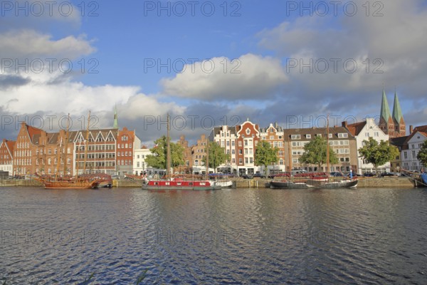 Ships on the banks of the Stadttrave, houses, cityscape, sailing ship, quay, harbour, steeples of St. Mary's Church, light atmosphere, old town, Lübeck, Schleswig-Holstein, Germany