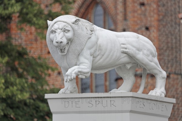 White Lion Monument by Peter Lenk 1996 with inscription The Trace of the Lion and monument to the city founder Henry the Lion Duke of Saxony, stone sculpture, modern art, city history, Am Markt, Schwerin, Mecklenburg-Vorpommern, Germany