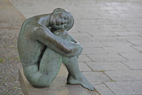 Sculpture Resting by August-Martin Hoffmann 1976, bronze sculpture, seated female figure on bench with head resting on knees, relax, resting, relax, contentment, joy, silence, calm, resting, legs, Schelfkirche, St. Nikolai, Schelfstadt, Schwerin, Mecklenburg-Vorpommern, Germany