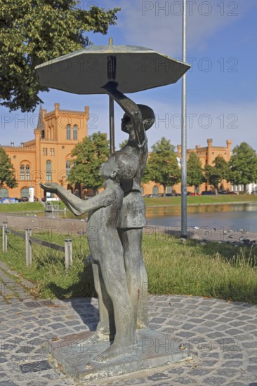 Sculpture Schirmkinder by Stephan Horota 1980, modern art, bronze sculpture, two children under an umbrella, protection from wetness and rain, standing, Arsenal, Pfaffenteich, Schwerin, Mecklenburg-Western Pomerania, Germany