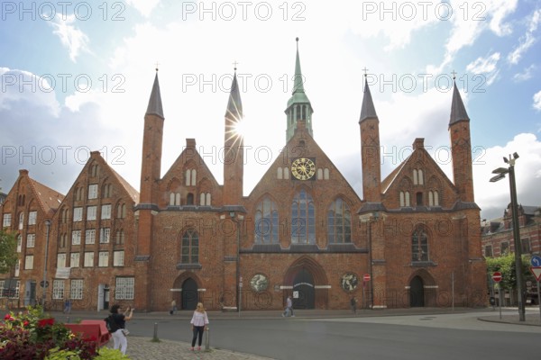 Holy Ghost Hospital backlit with pointed towers, Brick Gothic, Brick building, Old Town, Lübeck, Schleswig-Holstein, Germany