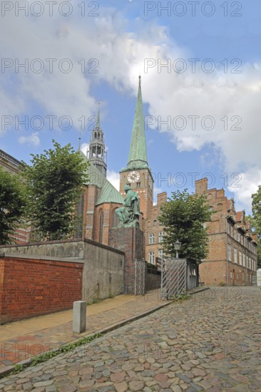 Monument to writer and poet Emanuel Geibel by Hermann Volz 1889 and St Jakobi Church, brick church, bronze sculpture, Old Town, Lübeck, Schleswig-Holstein, Germany