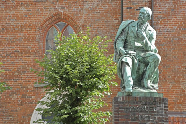 Monument to the writer and poet Emanuel Geibel by Hermann Volz 1889, seated, inscription, bronze sculpture, Grünspan, Geibelplatz, Old Town, Lübeck, Schleswig-Holstein, Germany