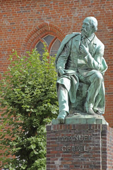 Monument to the writer and poet Emanuel Geibel by Hermann Volz 1889, seated, inscription, bronze sculpture, Grünspan, Geibelplatz, Old Town, Lübeck, Schleswig-Holstein, Germany
