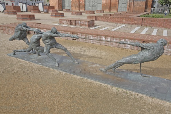 Tug-of-war by Karl-Henning Seemann 1987, bronze sculpture, modern art, tug-of-war, rope, sport, fighting, pulling, strength, St Mary's Church Tower, Wismar, Mecklenburg-Western Pomerania, Germany