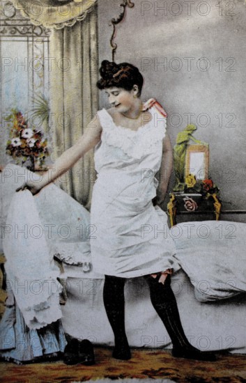 Female nude from around 1899, erotic postcard, playgirl, woman in nightgown looking at herself in the bedroom, which is decorated with flowers, coloured, reproduction of a photo from around the turn of the century, historical, digitally restored reproduction of an old original, exact date unknown