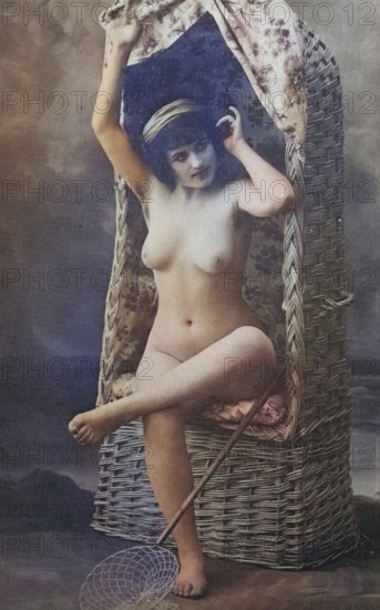 Female nude from around 1899, erotic postcard, Playgirl, A woman poses naked on an antique wicker chair with a net in her hand, coloured, reproduction from a photo around the turn of the century, Historical, digitally restored reproduction of an old original, exact date unknown