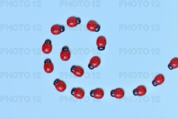 Small wooden ladybug ornaments on blue background