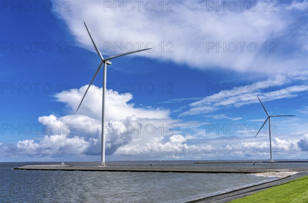 Strekdammen Wind Farm, wind farm at the seaport of Eemshaven in the Netherlands, built on offshore breakwaters, 2 GE Cypress 5, 5 MW turbines, with 158 metre blade diameter, together produce 11 MW of power, can supply 15, 500 households with electricity from wind, cumulus cloud over the North Sea, Netherlands
