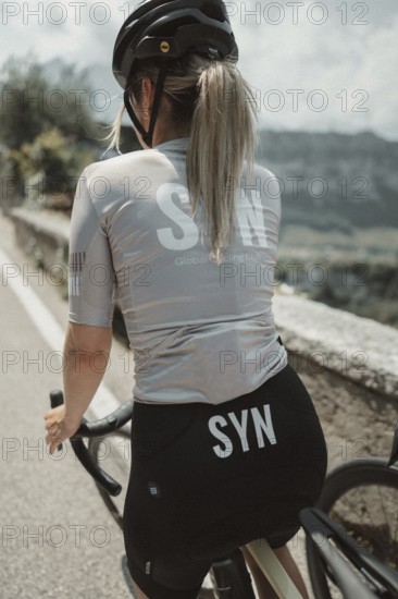 Young woman riding a racing bike on Lake Garda. Sunny weather and dolce vita