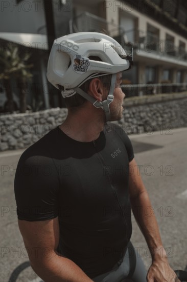 Young man riding a racing bike on Lake Garda. Sunny weather and dolce vita