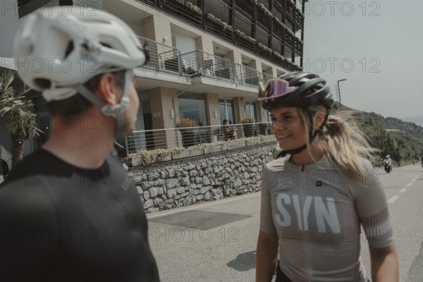 Woman and man cycling on Lake Garda in Italy. Sunny weather and dolce vita