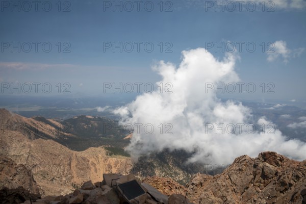 Colorado Springs, Colorado - Clourds rise near the summit of Pikes Peak, a 14, 115' mountain in Colorado's front range. Thousands of tourists visit, most by driving a steep road to the summit, or riding on a cog railway