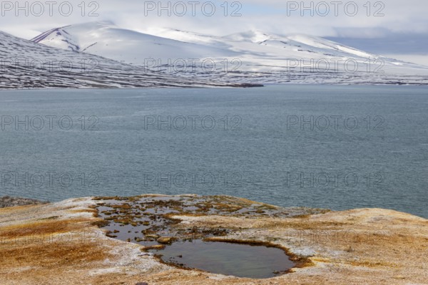 Discoloured rock, sinter, mountain range, sea, Jotunkjeldene, Spitsbergen, Svalbard