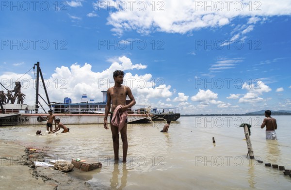People bathe in the Brahmaputra River to seek relief from the intense summer heat in Guwahati, India, on June 26, 2025