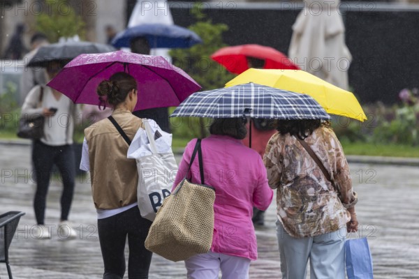 Rainy weather in Stuttgart. People with umbrellas hurry through the rain on Königstraße. Stuttgart, Baden-Württemberg, Germany