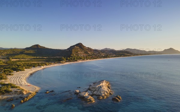 The light of the newly risen sun illuminates the Costa Rei, a stretch of coastline on the Italian Mediterranean island of Sardinia. (Aerial view with a drone), Monte Nai, Costa Rei, Sardinia, Italy