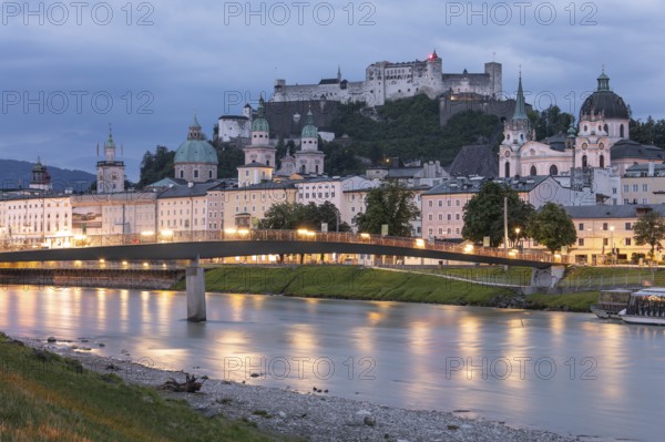 The city of Salzburg with the fortress on the Salzach shines in the first light of summer morning