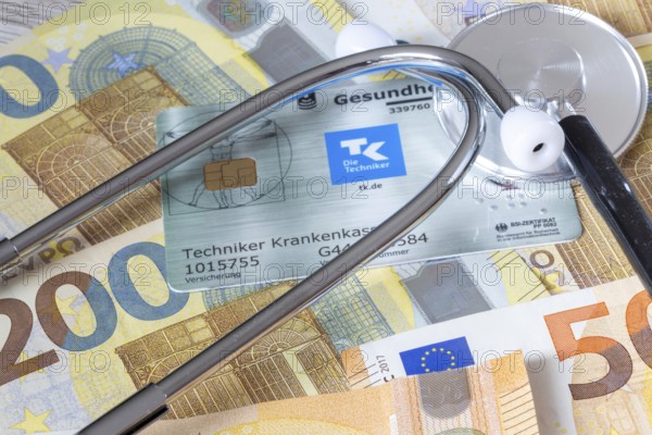Health insurance contributions Symbolic image: health card, stethoscope and cash