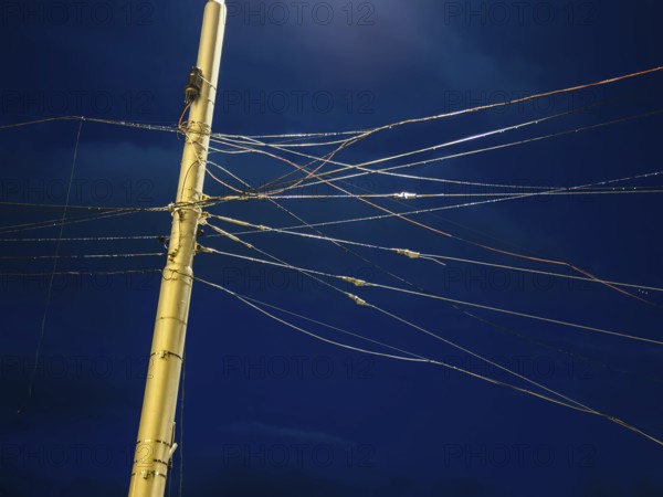 Night shot of many cables and wires for overhead lines on a lamppost in Bratislava, Slovakia