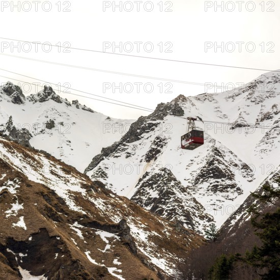 A gondola ascends the stunning Massif of Sancy, surrounded by a winter wonderland of snow-covered mountains in the Regional Natural Park of the Auvergne volcanoes. Puy de Dome. Auvergne Rhone Alpes. France