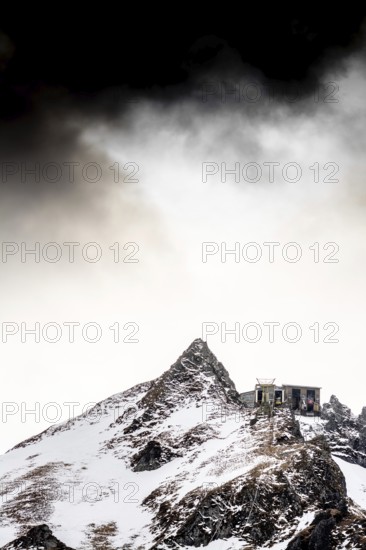 Snow blankets the peaks of Massif de Sancy, creating a serene winter landscape. The Regional Natural Park offers stunning volcanic formations under a moody sky. Puy de Dome. Auvergne Rhone Alpes. France