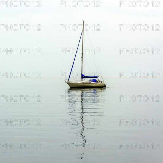 A sailing boat drifts smoothly over the serene waters of Lake Geneva, surrounded by a peaceful atmosphere. The soft ripples reflect the tranquility of the moment.. Switzerland