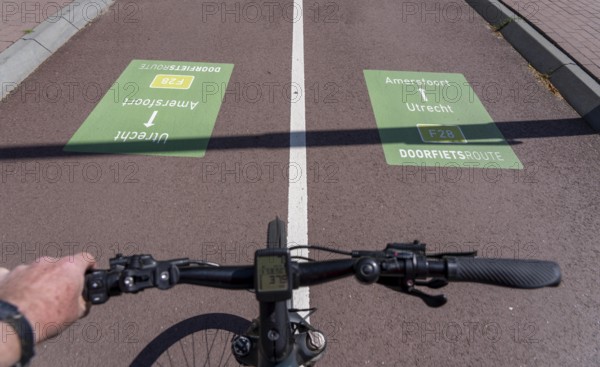 Long-distance cycle route F28, so-called Doorfietsroute, through cycle route, in the province of Utrecht, connects the city of Utrecht, as well as 4 municipalities and the city of Amersfoort, route signs on the road surface, part of a cycle path network, 21 KM long, mostly illuminated, mostly without crossings, pure cycle path, marked with red asphalt in town crossings, bicycles have priority over cars, completed in June 2025, Netherlands