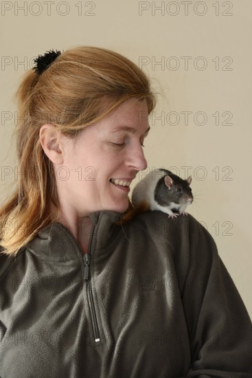 Woman with coloured rat (Rattus novegicus forma domestica) on her shoulder, North Rhine-Westphalia, Germany