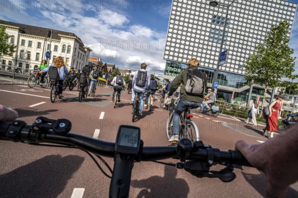 Ride your bike on the central cycle path on Lange Viestraat, Vredenburg, in the city centre of Utrecht, lanes for pedestrians, cyclists and public transport vehicles are separated, heavy cycle traffic, Netherlands