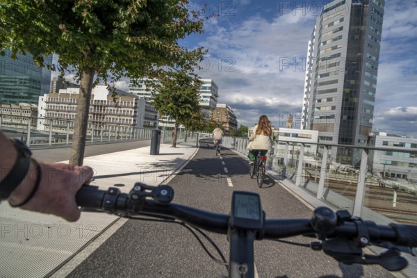 Cycling over the Moreelsebrug, pedestrian and cyclist bridge over the tracks of Utrecht Centraal, Central Station, Rabobank