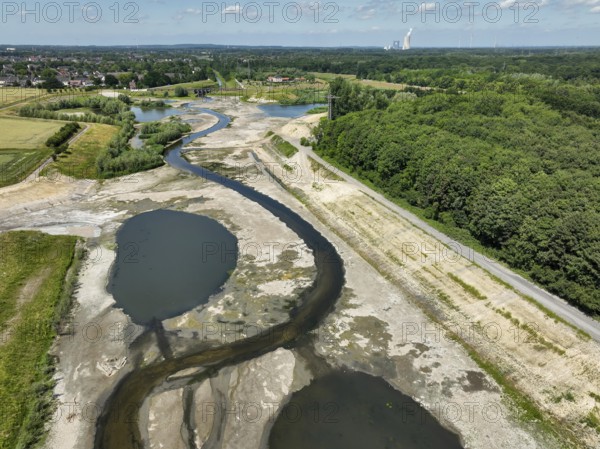 Dortmund, Castrop-Rauxel, North Rhine-Westphalia, Germany - River renaturalisation, renaturation of the Emscher, flood retention basin HRB Mengede. A new floodplain landscape is being created at the Emscher-Auen farm, expanding the area for flood protection during heavy rainfall and for biodiversity. The previously straightened Emscher is being given curves again and can meander through its new floodplain. Following the construction of a parallel sewer, the Emscher has been completely free of sewage since 2022. The river was previously an open, above-ground mixed water channel with rainwater and wastewater. At the back right, the Uniper coal-fired power plant Datteln 4 power station