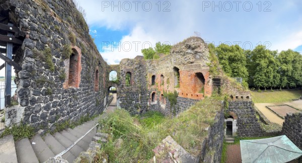 Panoramic photo of interior of northern inner part with partially restored secured masonry of ruins of imperial palace built in the Middle Ages around 1184 on today's banks of the Rhine by Emperor Frederick I Barbarossa, left staircase to upper floor, right at the edge of the picture today empty place of historic castle tower, tower of castle fortress, Kaiserswerth, Düsseldorf, North Rhine-Westphalia, Germany