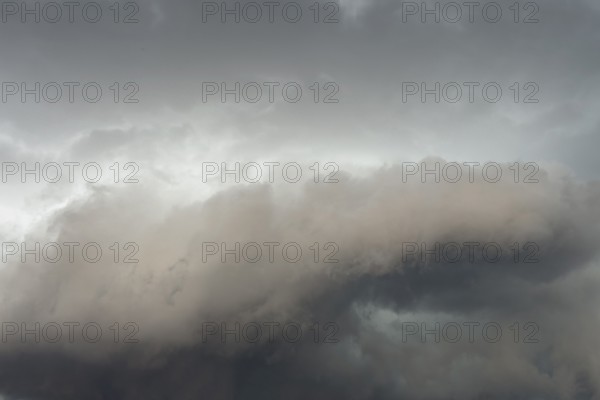Below dark discoloured storm clouds Cloud roll above grey clouds Rain clouds heralding thunderstorms, Germany