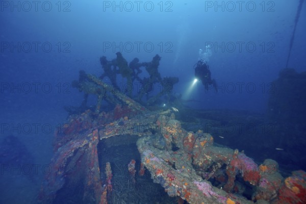 A diver explores a rusty shipwreck on the seabed. Dive site wreck Ville de Grasse, Giens peninsula, Mediterranean Sea, Provence Alpes Côte d'Azur, France