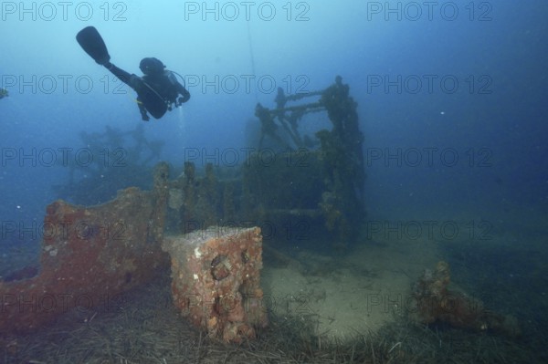 A diver examines an old shipwreck on the seabed. Dive site wreck Ville de Grasse, Giens peninsula, Mediterranean Sea, Provence Alpes Côte d'Azur, France