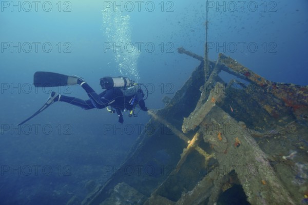 Diver floats near a shipwreck while air bubbles rise to the surface. Dive site wreck Michel C, Giens peninsula, Mediterranean Sea, Provence Alpes Côte d'Azur, France